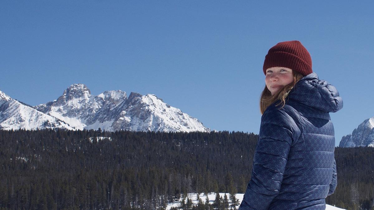 女子在滑雪山上的照片，背景是山.